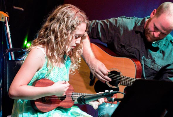 Girl plays ukulele with teacher