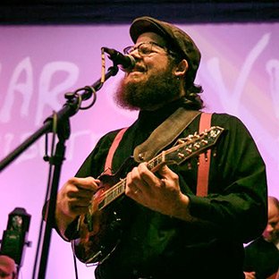 Teacher on stage playing mandolin