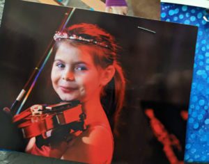 Young girl smiles while playing violin