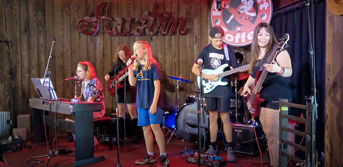 Student rock band plays on stage at a coffeehouse music venue